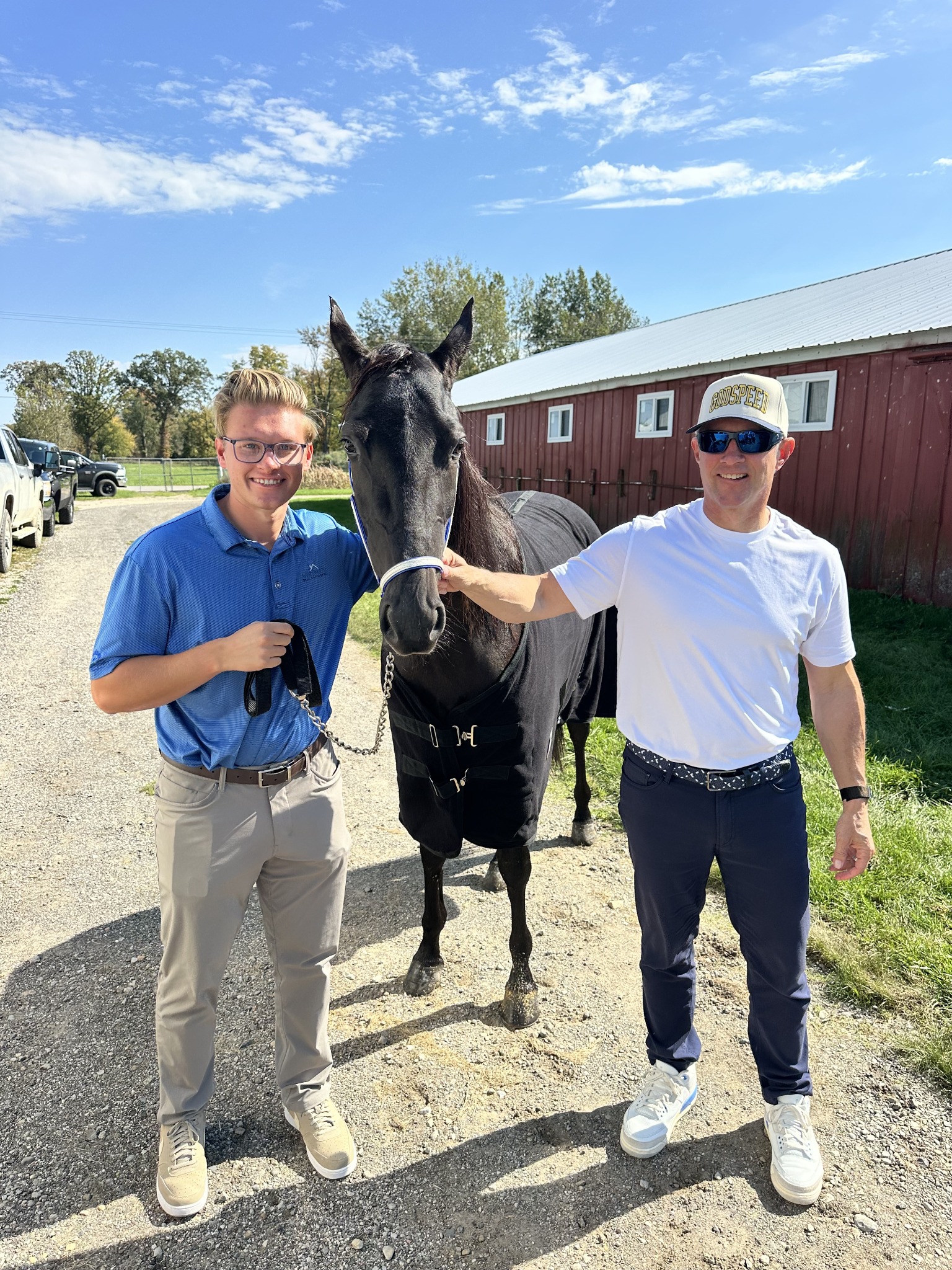 Owner and family member visiting a horse outside the barn